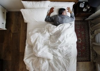 French man sleeping alone on bed