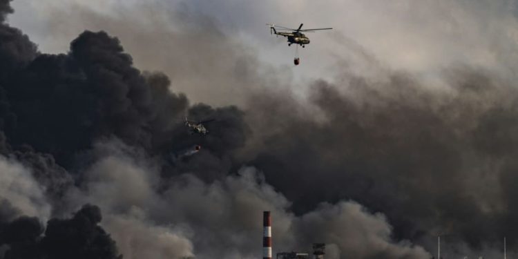 Un helicóptero lanza agua sobre un masivo incendio en un depósito de combustible provocado por un rayo en Matanzas, Cuba, el 8 de agosto de 2022.