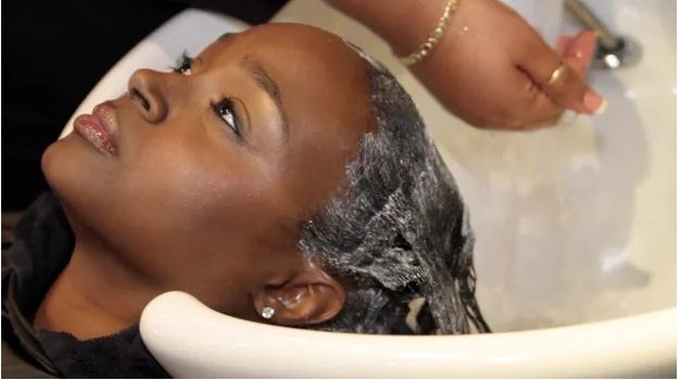 Una joven utilizando productos químicos para alisarse el cabello/Foto:Afroféminas