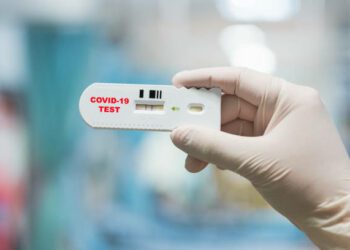 Mano de médico sosteniendo una prueba rápida positiva de Coronavirus o Covid-19. Getty images