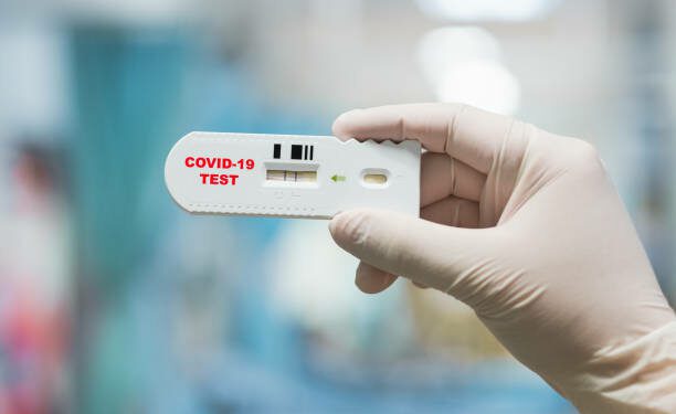 Mano de médico sosteniendo una prueba rápida positiva de Coronavirus o Covid-19. Getty images