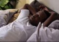 Joven apuesto hombre africano negro étnico descansando en la cama durmiendo o tomando una siesta/ Freepik