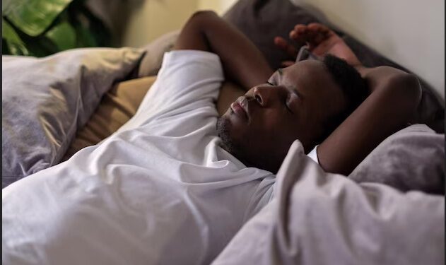 Joven apuesto hombre africano negro étnico descansando en la cama durmiendo o tomando una siesta/ Freepik