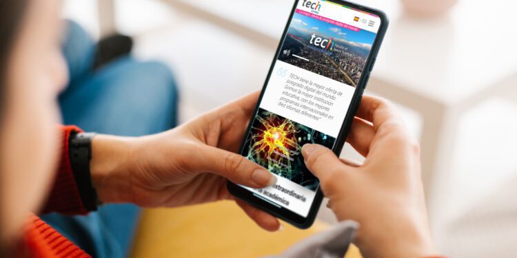 Unrecognizable young woman holding a mobile phone with white screen at home - Mockup for advertisement